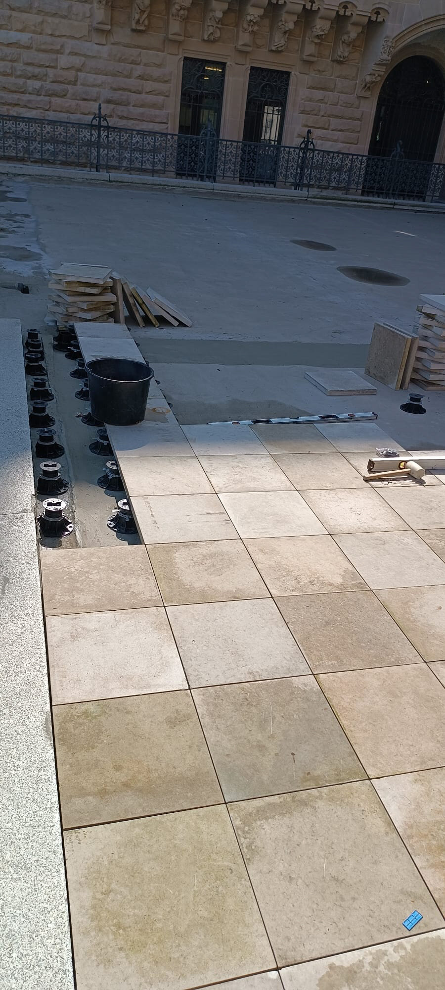 Montage de terrasse surélevée sur plots dans une cour fermée