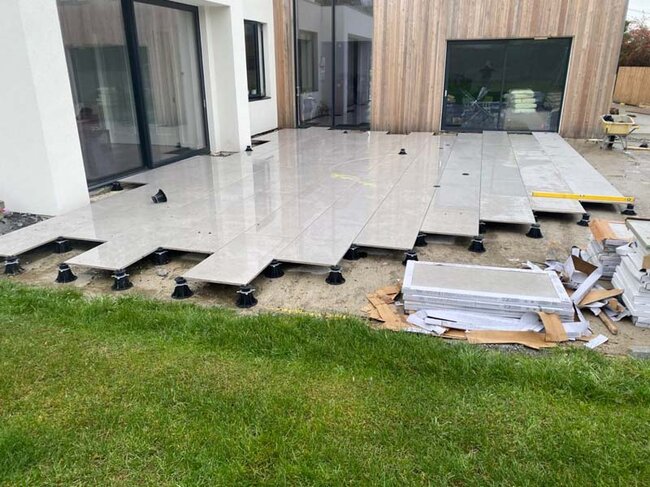 Construction d'une terrasse surélevée sur plots avec dalles pour terrasse de jardin