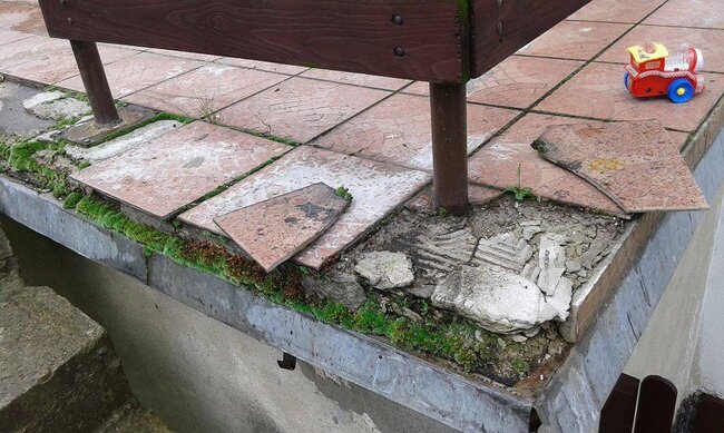 Dalles qui s'effritent et se détachent sur une terrasse traditionnelle collée