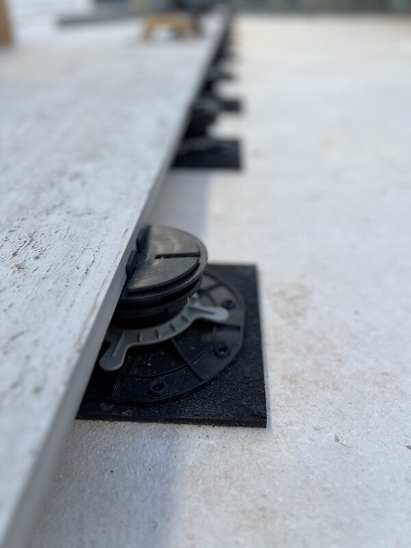 Plot de terrasse placé sous la dalle avec patin en granulés en caoutchouc SBR sous le plot