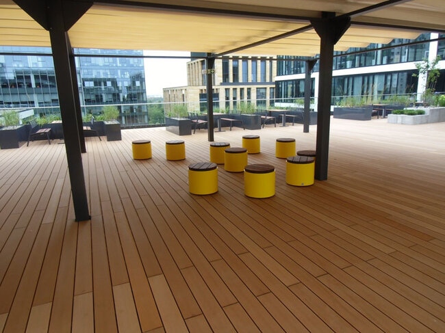 Espace commun sur le toit d'un immeuble de bureaux réalisé avec des lames composites