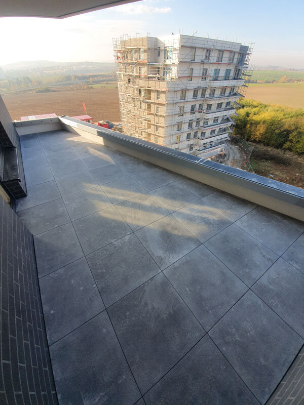 Vue sur une terrasse en dalles de béton sur un immeuble de grande hauteur