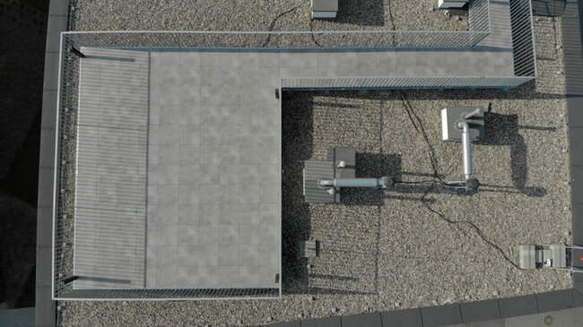 Vue de drone sur une terrasse sur toit plat accessible avec des dalles en grès sur plots