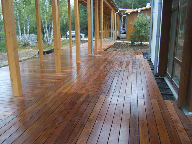 Grande terrasse en bois naturel au sol sur lambourdes et plots réglables solver