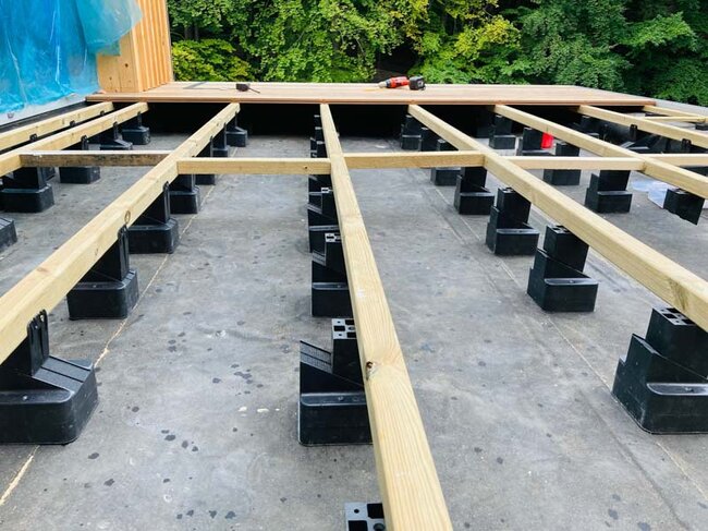 Plots réglables sur dalle de terrasse avec lambourdes de terrasse régulièrement espacées