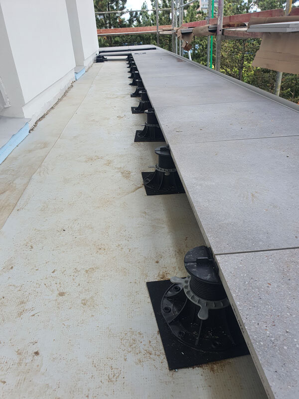 Plots posés sur du caoutchouc pour protéger l'étanchéité de la terrasse ou du toit