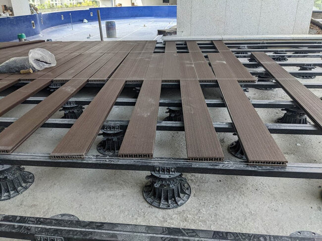 Terrasse en lames composites avec mobilier et foyer dans le jardin.