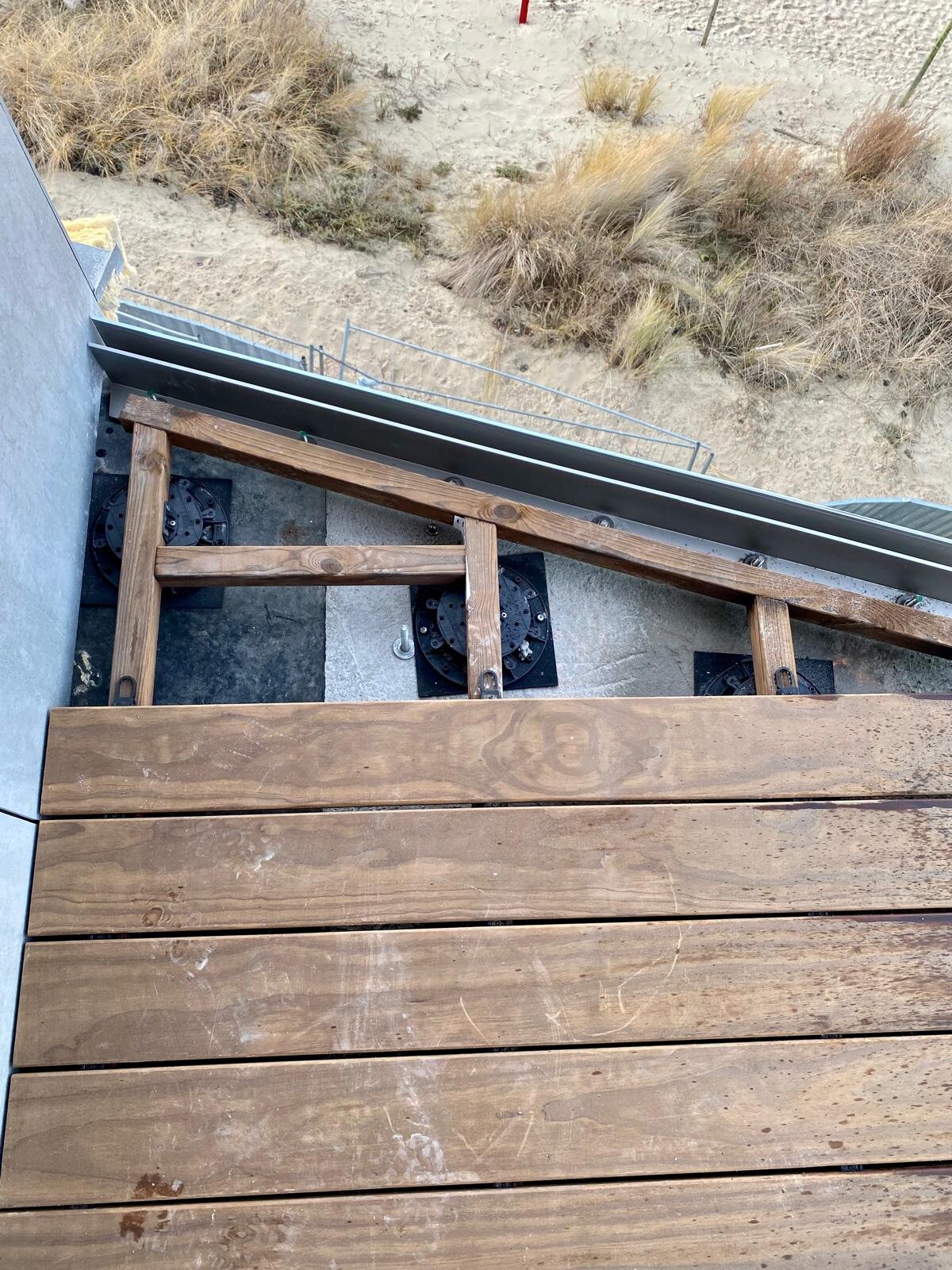 Montage d'une terrasse en bois sur plots réglables avec vue sur les dunes