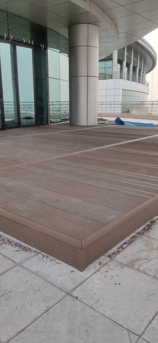 Terrasse en lames composites surélevée près d'un bâtiment moderne