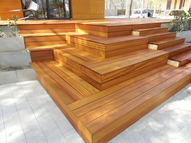 Terrasse en bois moderne avec escaliers en cascade et jardinières en béton