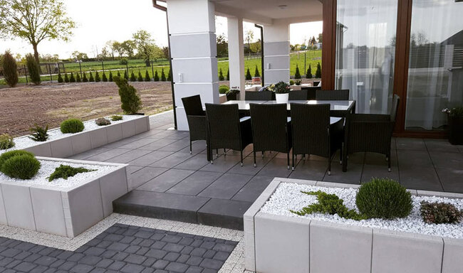 Moderne terrasse avec dalles surélevées sombres et mobilier de jardin