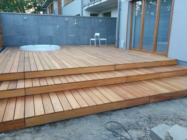 Terrasse en bois moderne avec escaliers et spa de jardin intégré