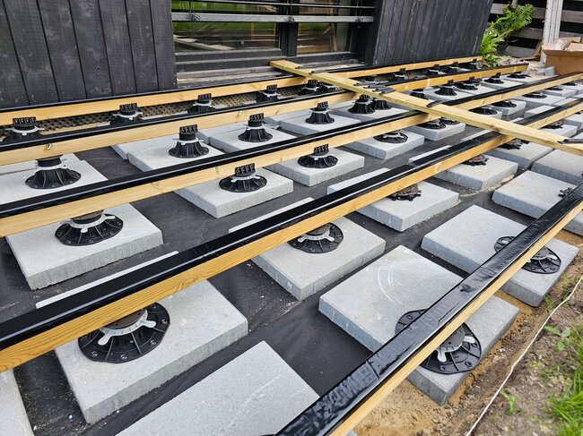 Sous-structure de terrasse en lambourdes en bois sur plots et dalles en béton