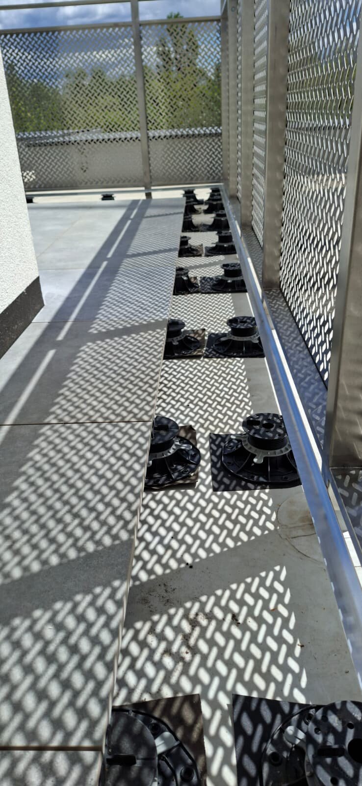 Plots réglables sous les dalles de terrasse près de la balustrade