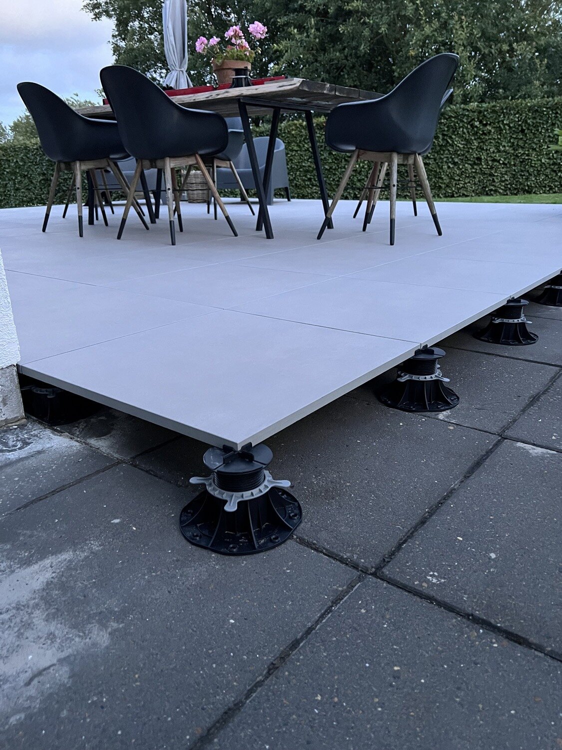 Vue de la sous-structure d'une terrasse surélevée avec des dalles en grès clair sur plots réglables