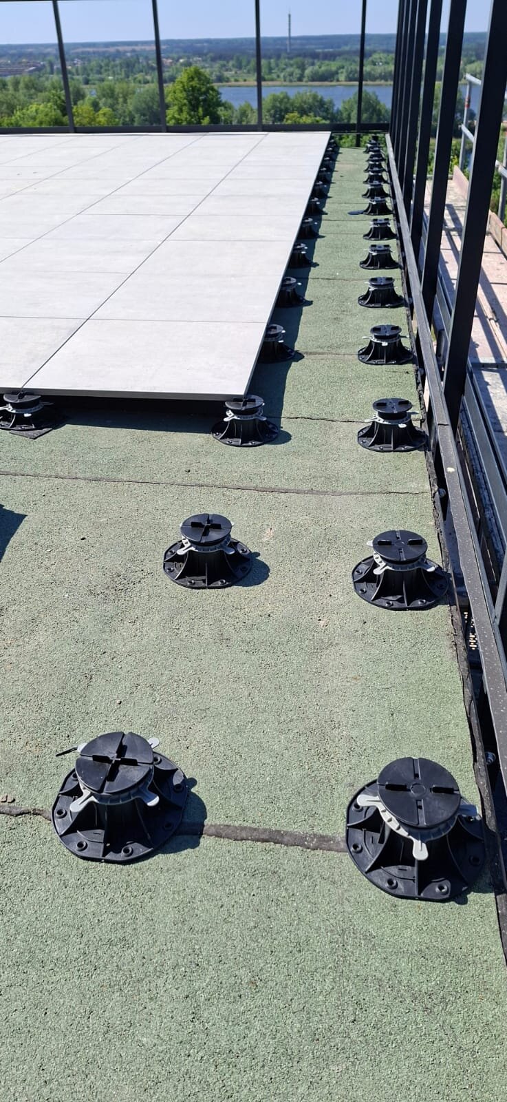 Montage des dalles céramiques sur plots réglables sur terrasse de toit