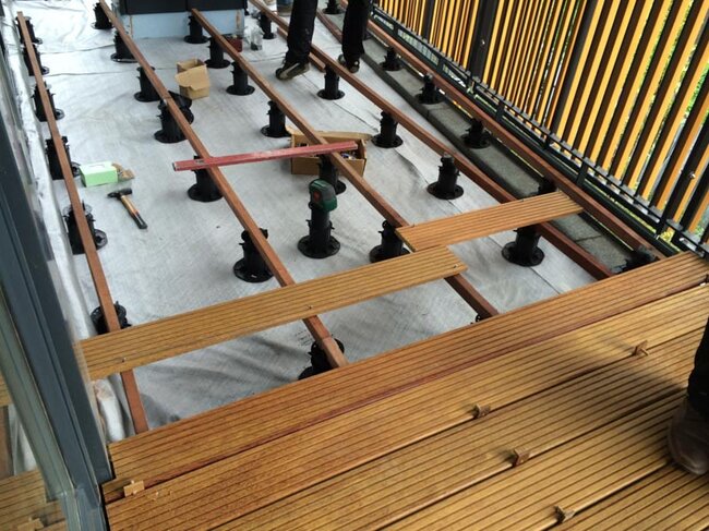 Montage d'une terrasse surélevée avec des dalles en grès sur plots réglables