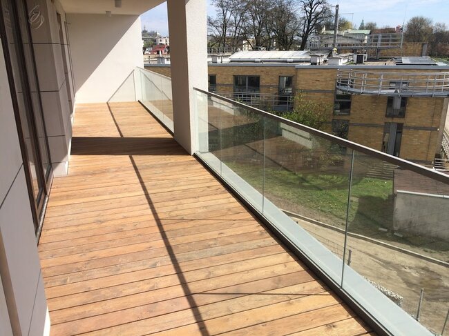 Moderne terrasse panoramique sur le toit avec zone barbecue et garde-corps en verre