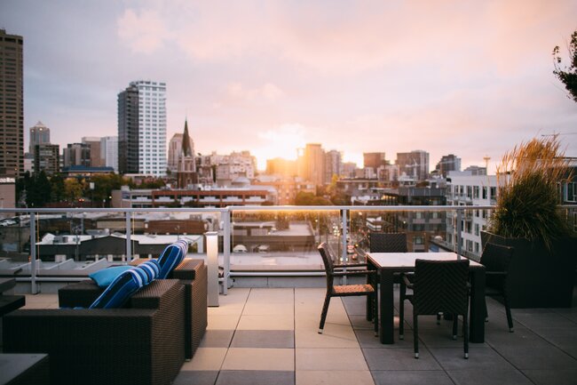 Terrasse surélevée moderne sur le toit avec du mobilier de jardin et une vue panoramique sur la ville