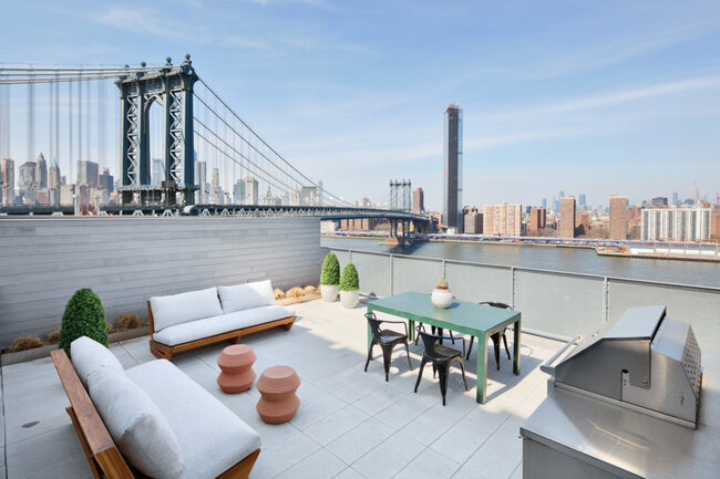 Terrasse de luxe sur le toit avec mobilier et vue sur le pont de Manhattan