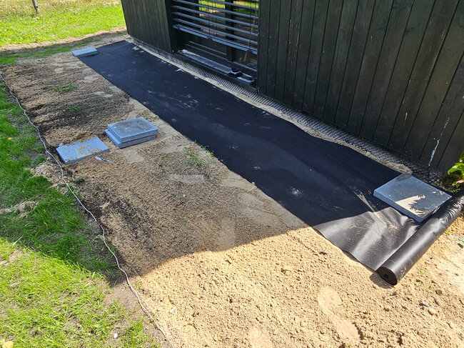 Préparation du support pour la construction d'une terrasse avec géotextile et blocs