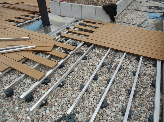 Construction d'une terrasse en bois sur lambourdes en aluminium et plots réglables