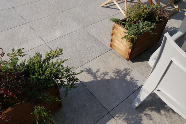 Dalles claires en grès sur terrasse surélevée avec pots de plantes