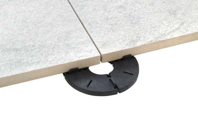 Photo montrant la réalisation d'un projet de terrasse en dalles de béton avec l'utilisation de plots de terrasse de hauteur fixe