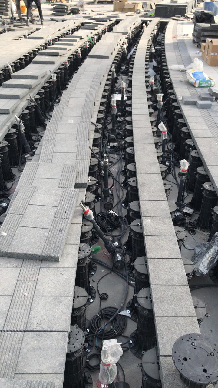 Photo d'une terrasse surélevée avec des dalles en céramique en cours de montage sur plots réglables STANDARD.