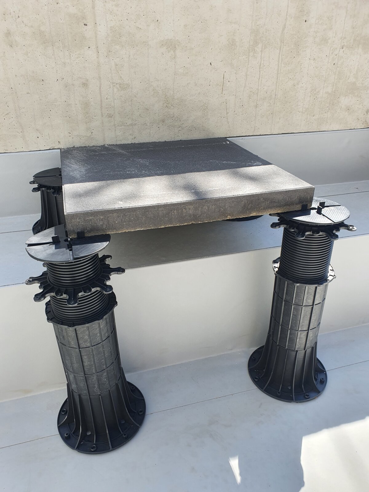 *Photo d'une terrasse surélevée sur le toit avec des dalles en béton et des plots réglables STANDARD.