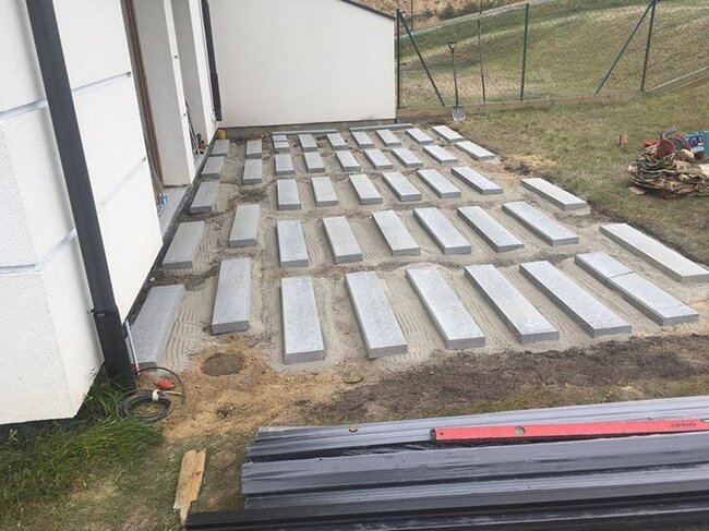 Sol choisi et dalles en béton posées préparées pour terrasse surélevée sur sol