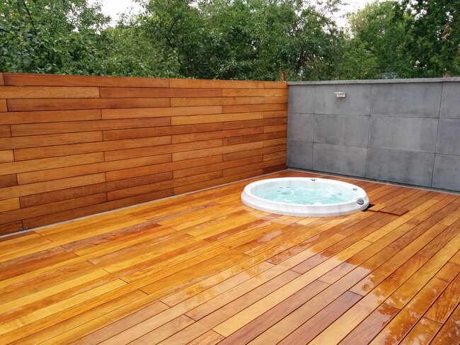 Jacuzzi sur terrasse surélevée avec lames en bois