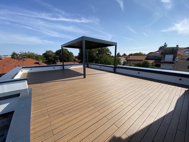 Terrasse surélevée en composite avec pergola couverte.