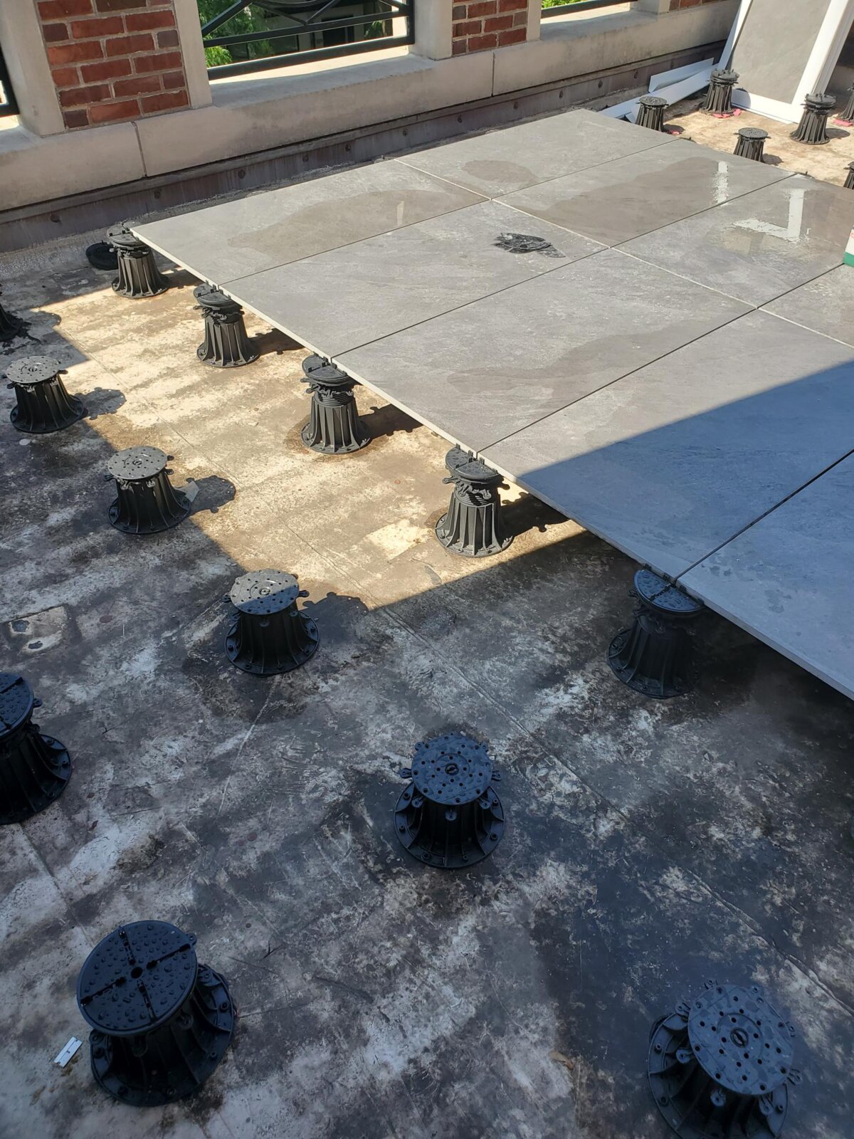 Długi balkon wykończony drewnianymi deskami tarasowymi z nowoczesną balustradą .
