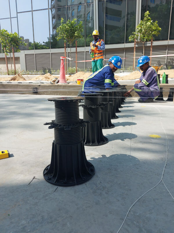 Nivellement des plots de terrasse sur le chantier.