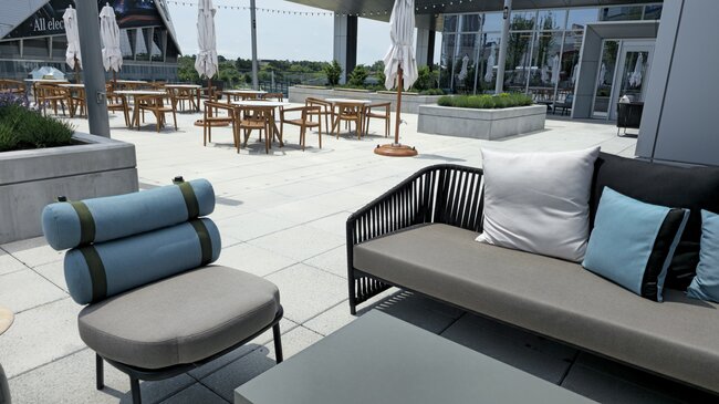 Zone de détente avec mobilier de jardin sur une grande terrasse surélevée en dalles
