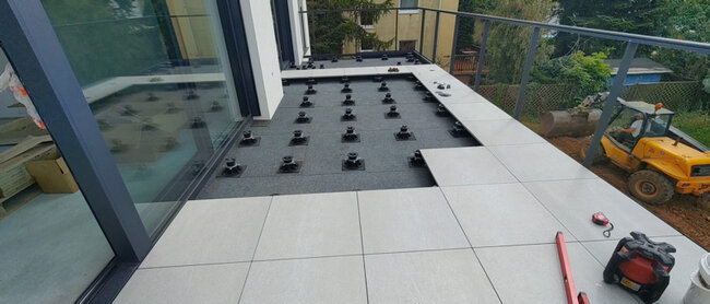 Pose de dalles en grès sur plots de terrasse