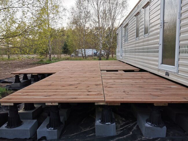 Construction d'une terrasse en lames de bois sur plots réglables hauts.