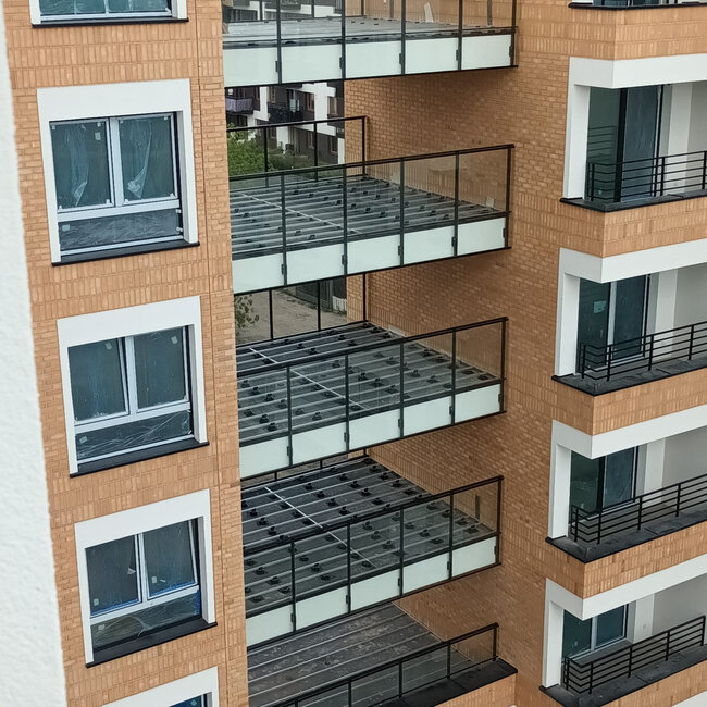 Sous-structures de balcon multi-étages avec lambourdes en aluminium soutenues par des plots réglables en plastique pour terrasse.