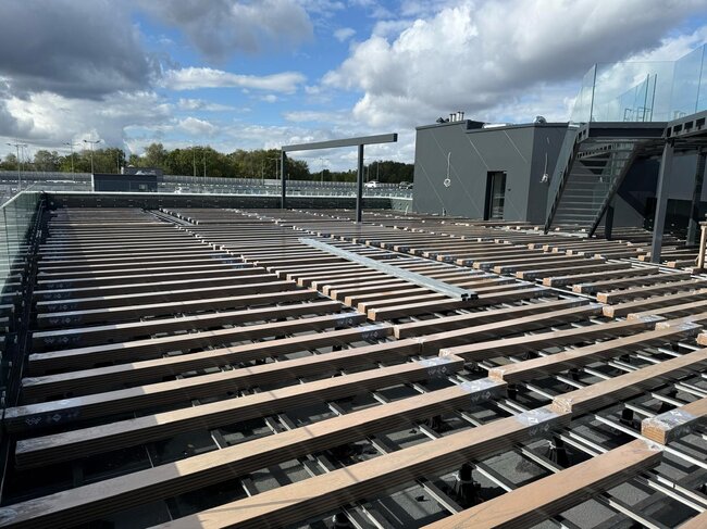 Sous-construction à lambourdes aluminium sur plots montée sous une terrasse sur toit moderne.
