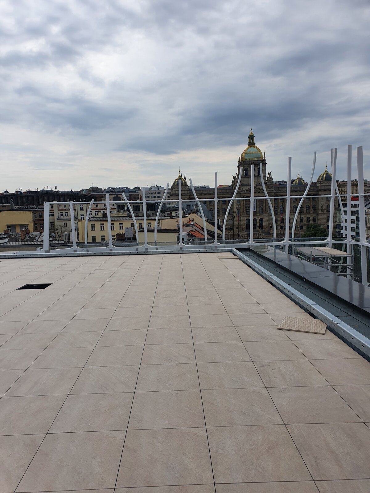 Terrasse sur toit avec dalles de terrasse extérieures en porcelaine installées, offrant une vue sur des bâtiments urbains historiques.