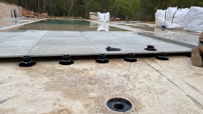 Installation de dalles de terrasse en porcelaine sur plots réglables de terrasse.