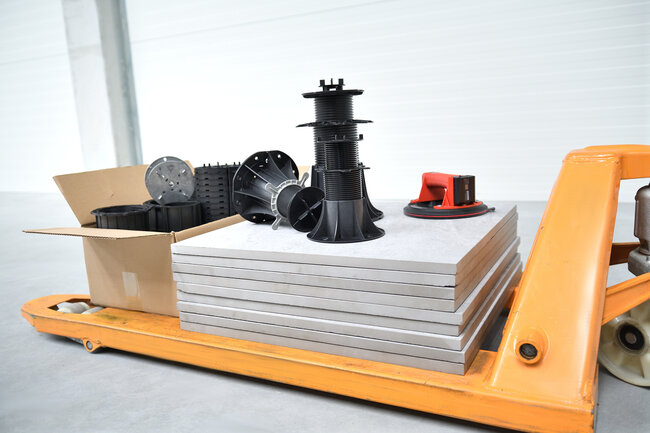 Plots réglables de terrasse empilés avec des dalles de terrasse pour une installation en extérieur.