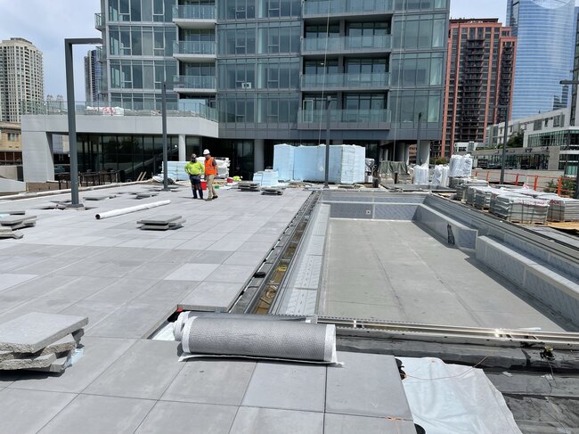 Piscine et terrasse sur toit commercial en construction.