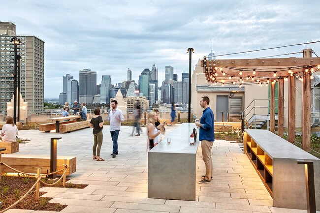 Terrasse de toit moderne avec dalles en pierre surélevées soutenues par des plots réglables.