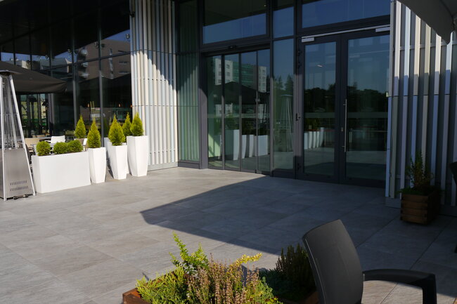 Commercial outdoor patio featuring raised porcelain tiles supported by adjustable pedestals.
