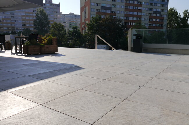 Système de dalles de terrasse sur toit plat installé sur des plots réglables de terrasse.